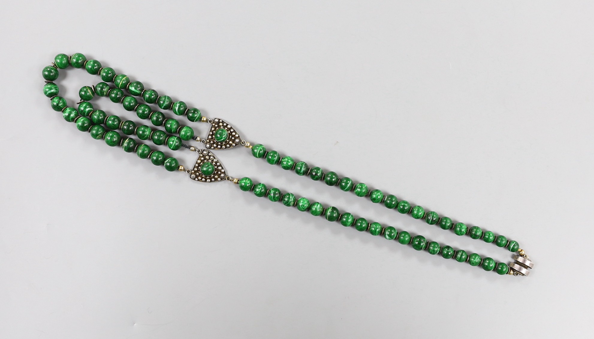 A 20th century Chinese single/double strand malachite bead necklace, with white metal clasp and triangular motifs, stamped 'China Liu Silver', 67cm.